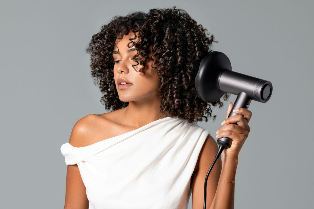 Woman drying her curly hair.